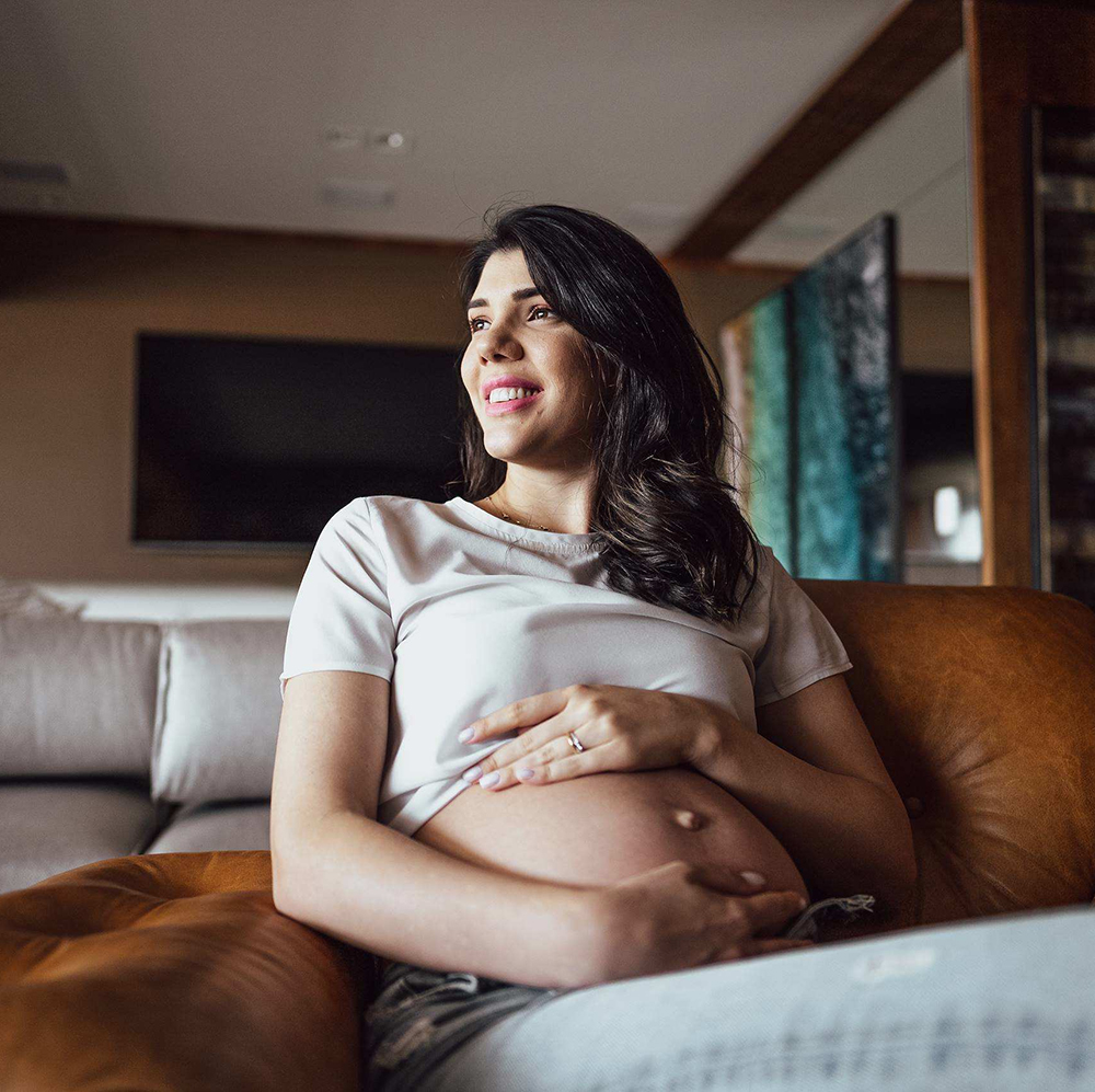 A pregnant woman sitting on a couch