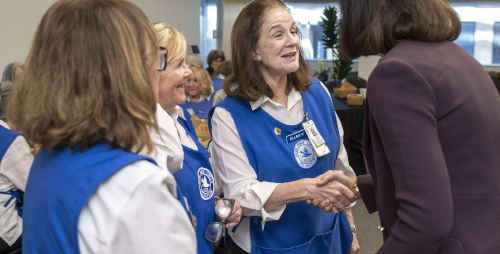 Group of women advocates shaking hands with a person at a social event