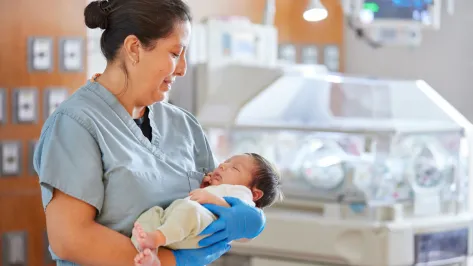 Nurse in NICU with baby